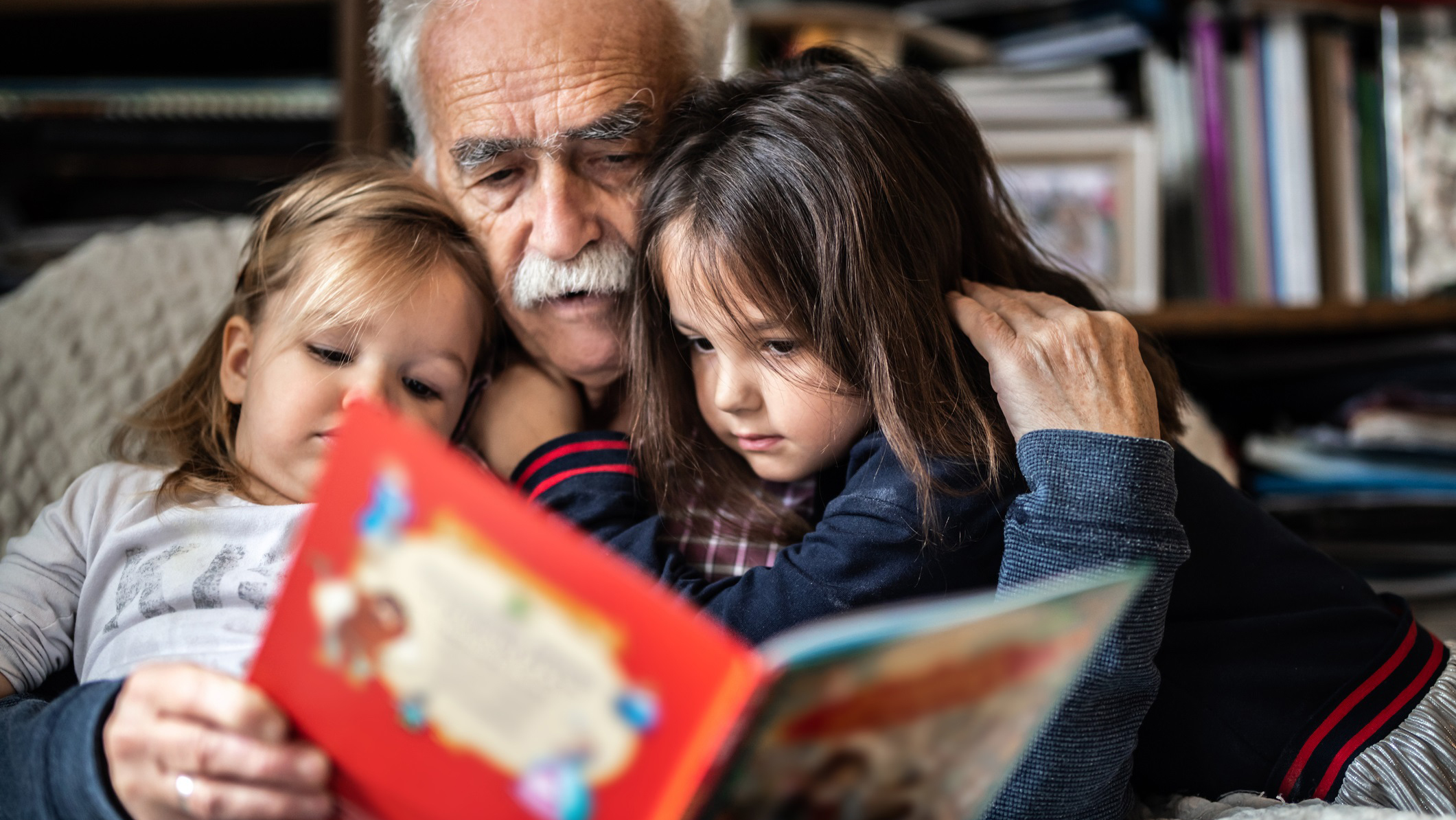 Grandfather and grandchildren reading